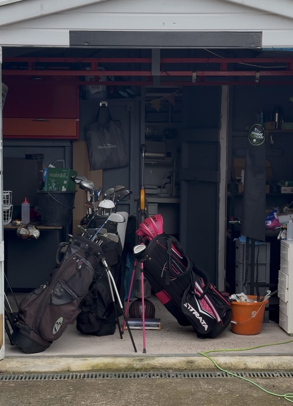 The Gimme ClubCare workspace with golf bags and clubs ready for care